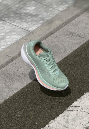 Light green athletic shoe with a breathable mesh upper, white midsole, and peach accents. Features a rounded toe and textured sole for grip.