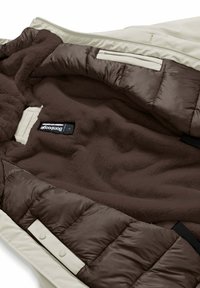 Geïsoleerde jas met een interieur van donkerbruin fleece, voorzien van een gestikte bruine puffervoering en een gladde, off-white buitenkant met ritsen.