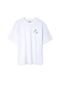 Witte katoenen t-shirt met korte mouwen en een geribbelde ronde hals. Kleine, decoratieve letters "P", "K" in zilveren accenten op de voorkant.