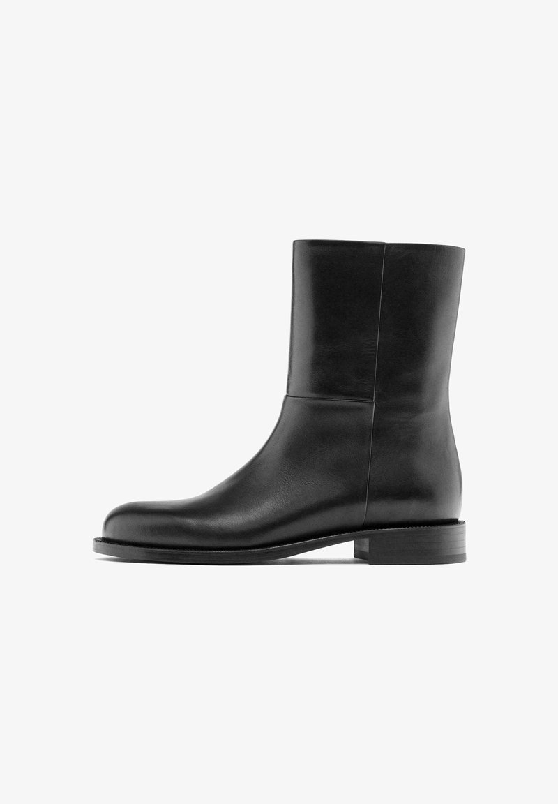 Black leather ankle boot with a smooth texture, minimalist design, round toe, and low stacked heel. No visible hardware details.