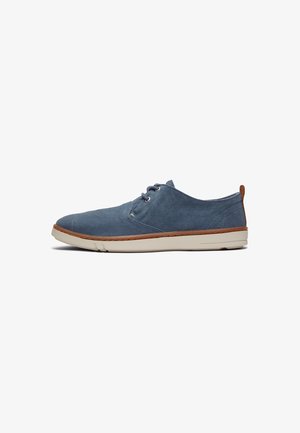 Blauer Leinenschuh mit runder Zehenpartie, Schnürdesign, cremefarbenem Gummisohle und braunem Lederakzent an der Ferse. Flache, strukturierte Oberfläche.