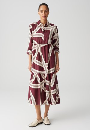 Weinrot und cremefarbenes gemustertes Kleid mit Kragen, langen Ärmeln und einem gestuften Rock. Hergestellt aus leichtem Stoff mit lockerer Passform.