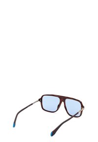 Occhiali da sole in acetato marrone con lenti quadrate, vetro leggermente colorato di blu, dettagli dorati e punte blu sulle astine scure marroni.