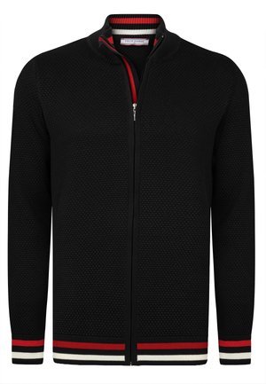 Cárdigan de punto negro con cremallera, con un patrón texturizado que presenta acentos en los puños y el cuello a rayas en rojo, blanco y negro. Cierre frontal con cremallera.