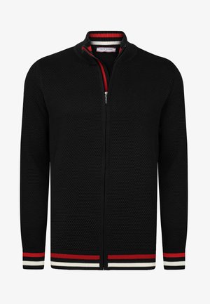 Mustra ja tekstuuriga musta kudumisega jakki, millel on triibulised punased, valged ja mustad mansetid ning krae. Ees lukuga sulgemine.