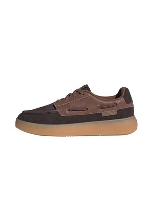 Zapatilla baja en marrón oscuro y claro con cordones delanteros y suela de goma translúcida, detalle del logo lateral.