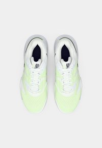 Helerohelised ja valged sportkingad. Võrgust paneelid, pehmendustega keeled ja aukudega varbasaapad. Valged paelad ja kummist tallad.