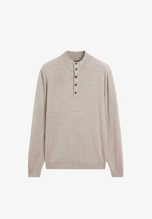 Pull long beige clair avec col montant côtelé et cinq boutons noirs sur le devant.