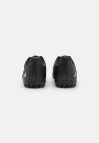 Schwarze Sportschuhe mit strukturierter Oberseite, verstärktem Fersenbereich, flexibler Sohle und markanten Gummistollen für besseren Halt.