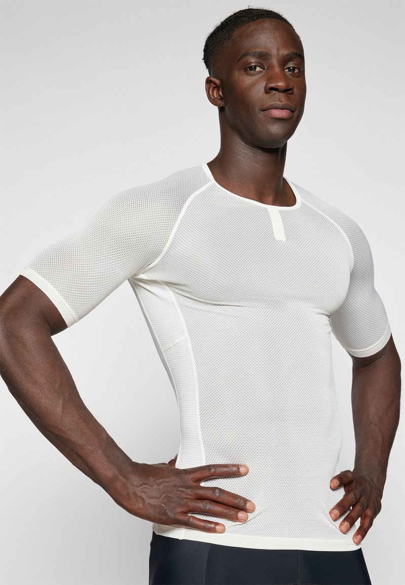 T-shirt de sport en maille blanche à manches courtes. Doté d'un col rond et d'un tissu texturé qui permet une bonne respirabilité. Design ajusté.