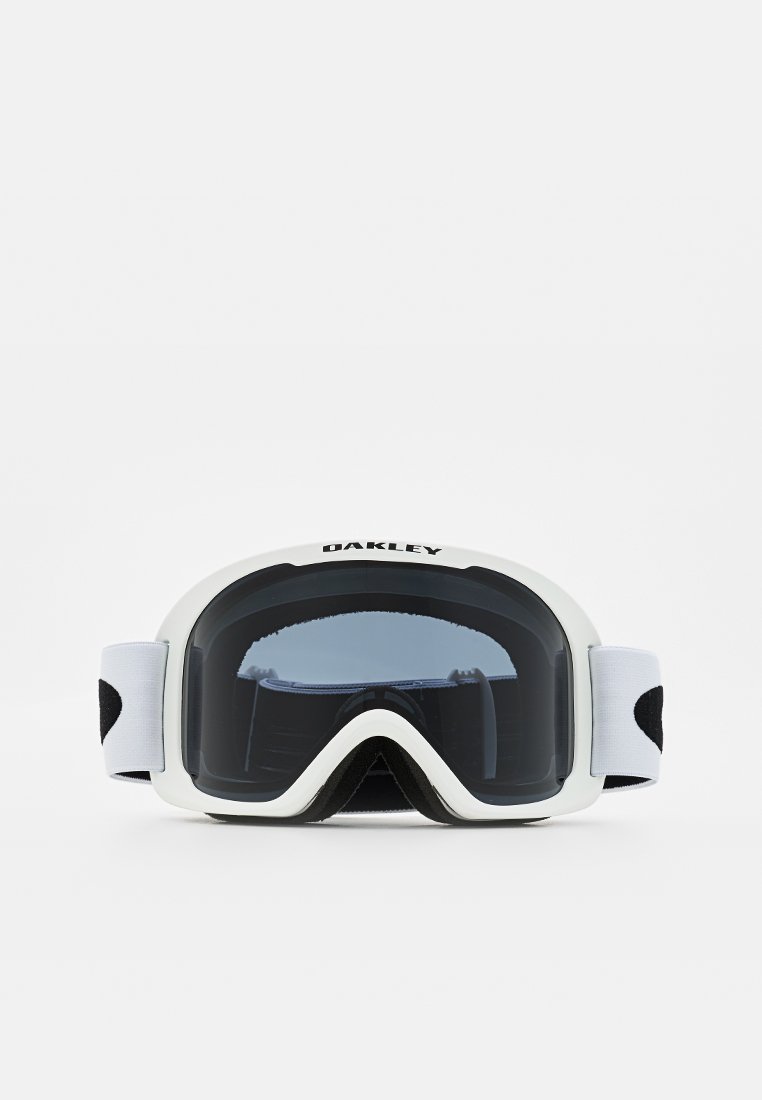 Occhiali da sci Oakley bianchi con lenti nere oscurate e cinturino regolabile bianco su uno sfondo neutro.