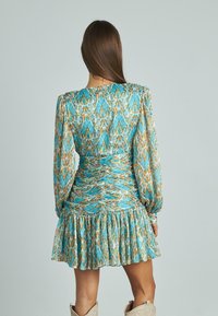Vestido mini con estampado floral en tonos azules y naranjas, con mangas largas abullonadas, cintura fruncida y dobladillo con volantes en capas.