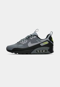 Nike Air Max sneakers, featuring a gray mesh and synthetic upper, black sole, and visible air cushioning in the heel, with neon green accents.