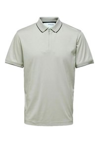 Polo shirt gris clair avec une demi-fermeture éclair, bord noir au col et aux manches, fabriqué en tissu lisse, affichant un design à coupe décontractée.