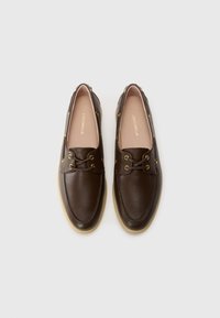 Brown leather shoes with a rounded toe, gold eyelets, and a beige rubber sole. Features a lace-up design and smooth texture.