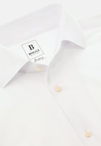 Camicia bianca con colletto all'americana e bottoni beige, con etichetta Boggi Milano all'interno del colletto.