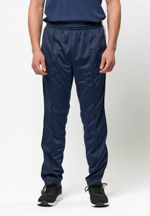 Marine atletiske bukser laget av glatt polyester med elastisk midjebånd, innsnevret passform og kontrasterende sidelister.