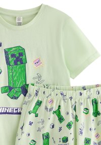 Világoszöld, Minecraft témájú rövid ujjú felső és rövidnadrág szett zöld Creeper karakterekkel, TNT blokkokkal és pixeles játékkal ellátott ikonokkal.
