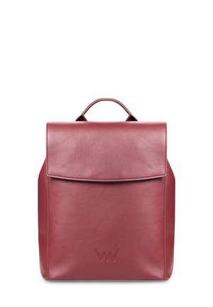 Dunkelroter Leder-Rucksack mit Klappe, oberem Griff und Seitentasche. Getragen mit einem grauen, strukturierten Mantel und einer blauen Strickmütze.