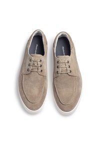 Scarpe in suede marrone chiaro con punta arrotondata, due occhielli per i lacci e suole in gomma bianca. Interno foderato in tessuto a contrasto.