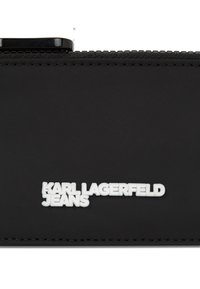 Melnas neilona maku ar izceltiem baltajiem uzrakstiem "KARL LAGERFELD JEANS" un teksturētu rāvējslēdzēja malu. Kompakts taisnstūra dizains.