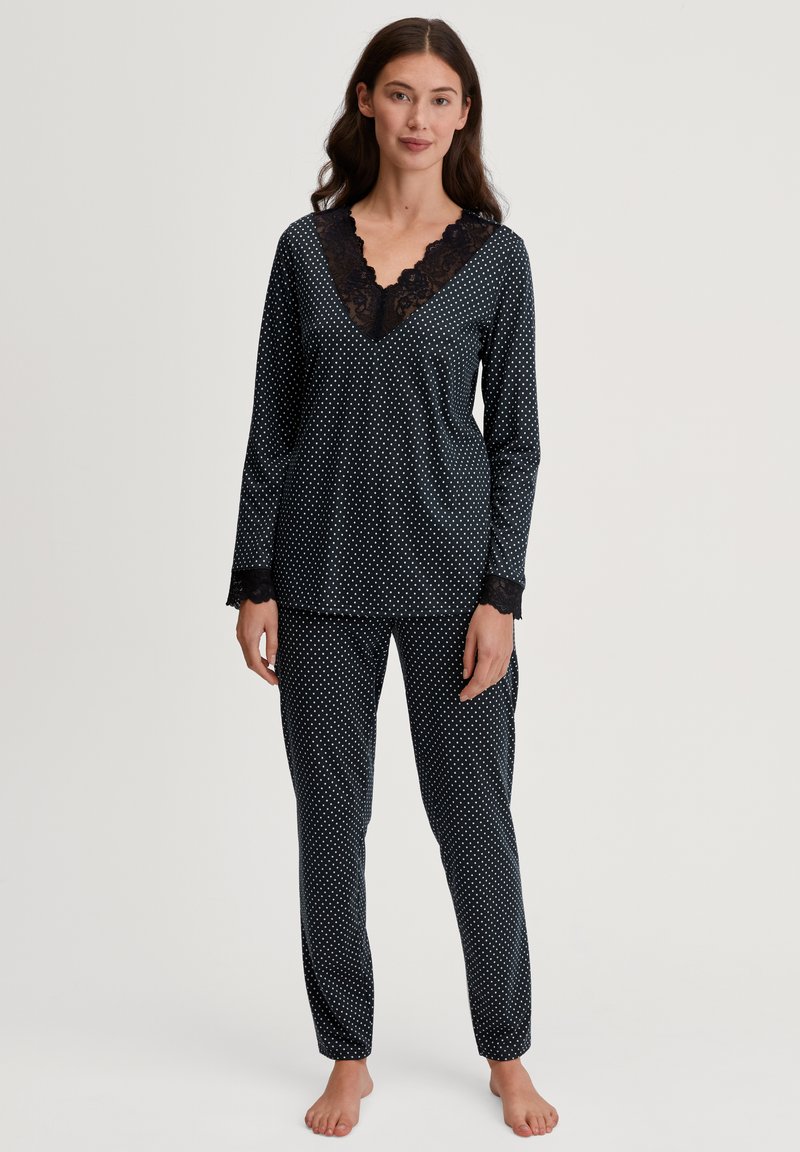 Zwart pyjama set met stippen, met lange mouwen, V-hals met kantafwerking, en bijpassende broek met elastische boorden en een losse pasvorm.