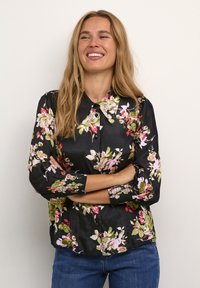 Černá květinová blůza s límečkem, zdobená růžovými a zelenými květinami. Dlouhé rukávy se shromážděnými manžetami a zapínáním na knoflík. Hladká textura látky.