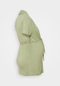 Vestido envolvente curto, de mangas curtas, na cor verde, feito de um tecido suave e elástico. Apresenta um laço na cintura e um corte descontraído. Textura lisa, design simples.