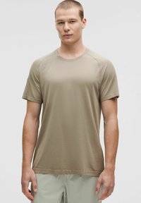 Kurzärmliges, Rundhals-T-Shirt in einem muted beige Farbton, aus strukturiertem Stoff mit subtiler Rippung, das eine enganliegende Silhouette bietet.