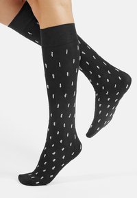 Black knee-high socks with a soft texture, featuring a scattered white dot pattern, and a solid black band at the top.