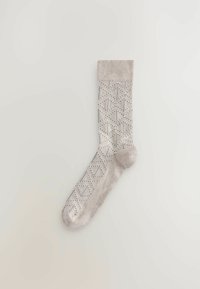 Chaussette beige en matériau respirant, avec un motif géométrique dans des teintes plus foncées, un haut côtelé, et des zones renforcées au talon et aux orteils.