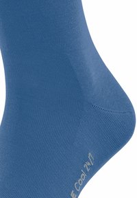 Chaussette en bleu, fabriquée dans un matériau lisse et extensible. Présente une texture côtelée et un design de orteil sans couture. Logo "Cool" près du talon.