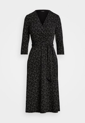 Vestido cruzado negro con estampado salpicado blanco, mangas tres cuartos, escote en V y cinturón anudado en la cintura, estilo hasta la rodilla.