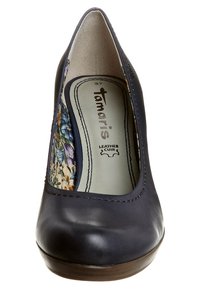 Marinblå läderhögklackad sko med blommönstrad tygdetalj på sidorna, med rund tå och slät yta. Märke: Tamaris.