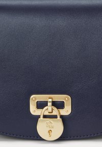 Navy leather bag with a textured finish, featuring a gold-tone lock closure and rectangular hardware detail.