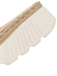 Close-up of beige shoe sole with textured white rubber outsole featuring vertical grooves and stitched midsole detail.