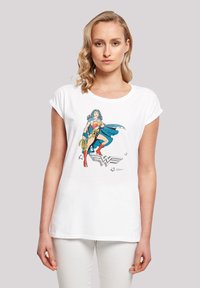 White cotton t-shirt featuring a colorful graphic of a female superhero in a blue costume with a lasso, set against a simple background.