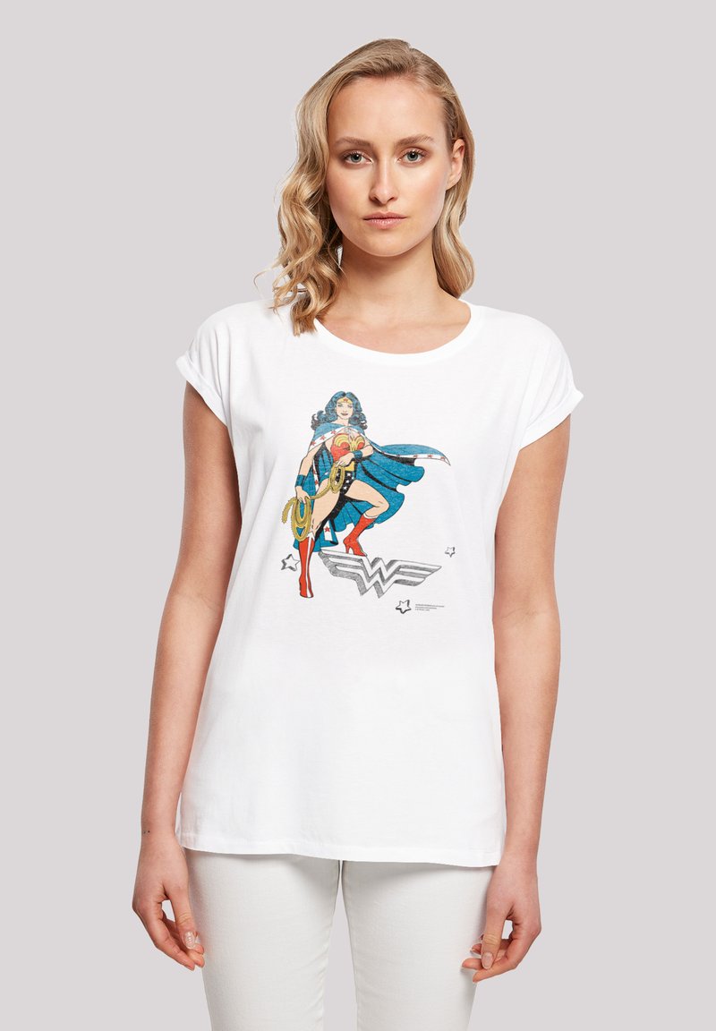 White cotton t-shirt featuring a colorful graphic of a female superhero in a blue costume with a lasso, set against a simple background.