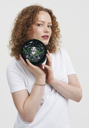 Round black embroidery case featuring a badger surrounded by ferns and flowers, intricate detailing in vibrant colors.