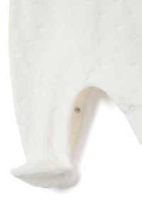 Romper blanc en tissu doux, arborant un motif de cœurs en relief, une fermeture à pression et des pieds enfermés pour plus de chaleur.