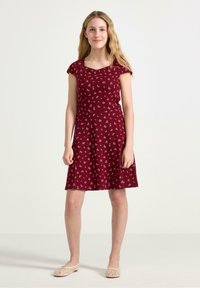 Bourgogne kjole med capærmer og firkantet udskæring, prydet med et blomstermønster i hvid og beige, som udvider sig fra taljen.