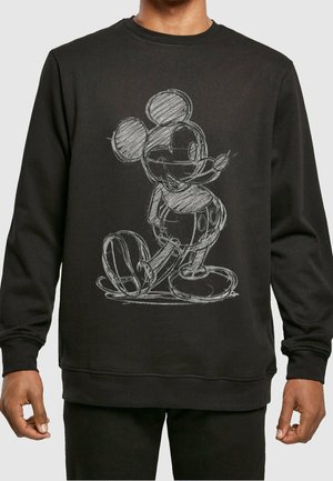 Chemise noire à manches longues avec un motif Mickey Mouse style croquis blanc centré sur le devant, portée par une personne avec un pantalon foncé.