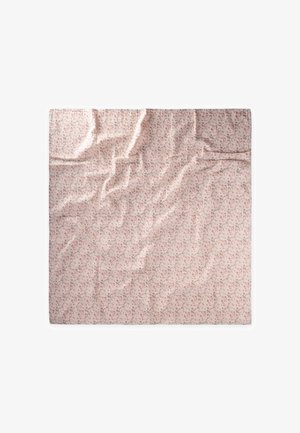 Carré de tissu rose avec un petit motif floral, légèrement froissé, étalé à plat sur un fond blanc.