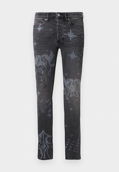 Μαύρο στενό τζιν με ξεθωριασμένα ουράνια και αγγελικά σχέδια, που περιλαμβάνουν αστέρια, αγγελούδια και σταυρούς, εμπρός όψη, με κούμπωμα κουμπιού και φερμουάρ.