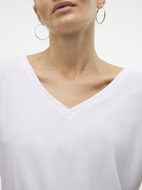 Tricou alb cu decolteu în V, cu mâneci scurte, realizat dintr-un material de bumbac neted. Are o croială relaxată și detalii minime de cusătură. Design simplu.