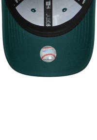 Cappello verde con visiera nera. Fronte con un adesivo riflettente della MLB. All'interno presenta una fodera bianca con dettagli e cuciture verdi.