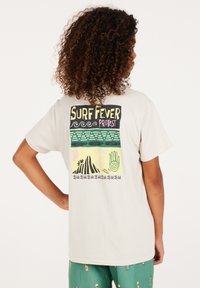 Beige katoenen t-shirt met een kleurrafische afbeelding op de achterkant met de tekst "SURF FEVER PROTEST," golven, palmbomen en abstracte patronen.