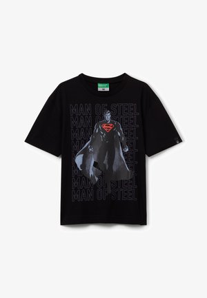 Schwarzes T-Shirt mit kurzen Ärmeln, das ein Grafikdesign eines Superhelden mit Umhang zeigt, mit wiederholt im Hintergrund in Dunkelblau geschriebenem Text "MAN OF STEEL".