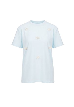 Lyseblå kortærmet T-shirt med seks hvide blomsterapplikationer jævnt fordelt på fronten. Ingen synligt branding eller grafik.