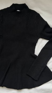 Pulover negru cu model cu dungi, cu guler înalt și mâneci lungi, având tiv evazat. Material texturat cu dungi verticale.